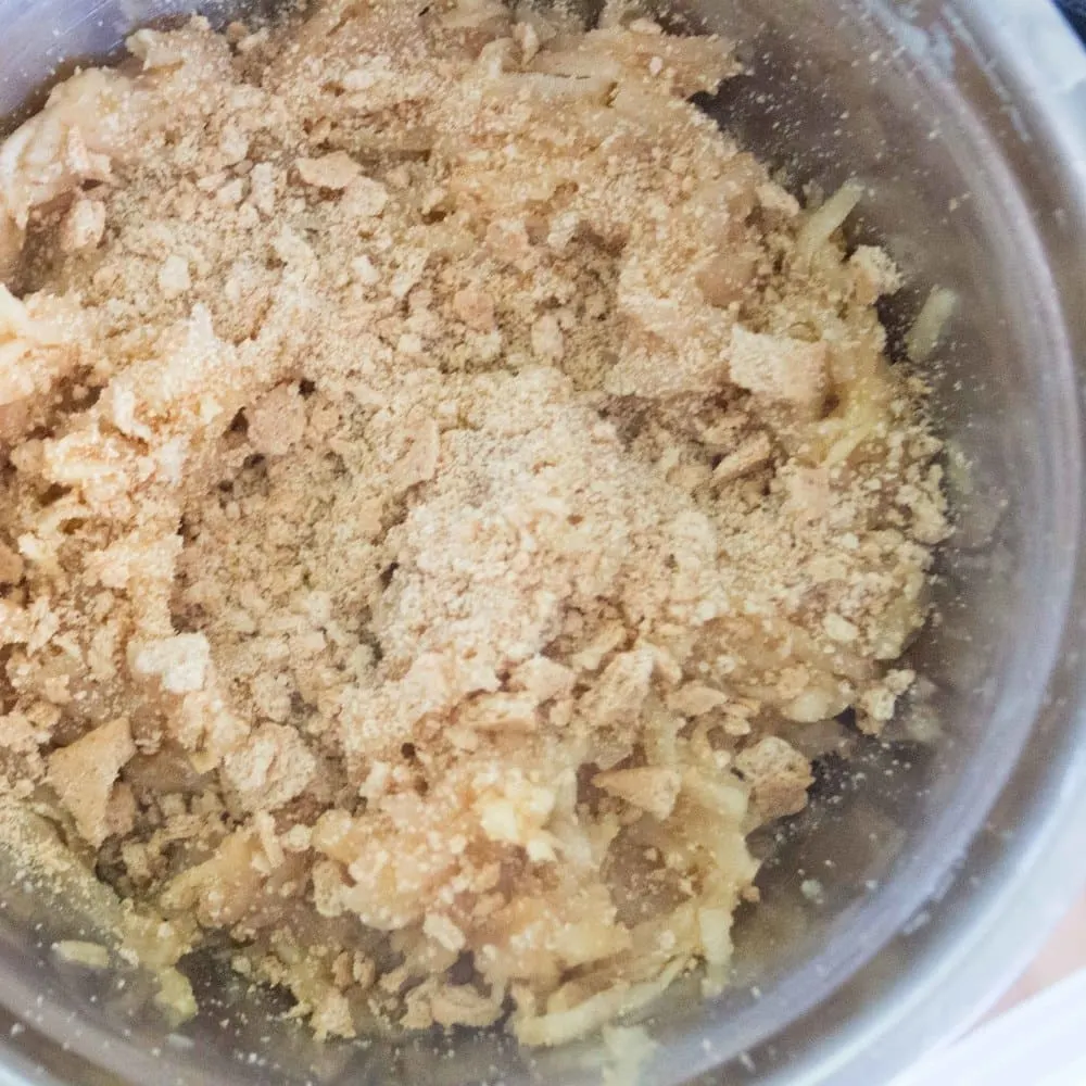 Cookie crumbs being combined into the sauteed cinnamon apple mixture