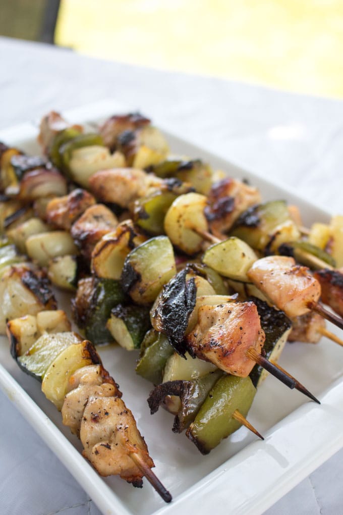 Platter filled with grilled chicken and veggie shish kabob skewers
