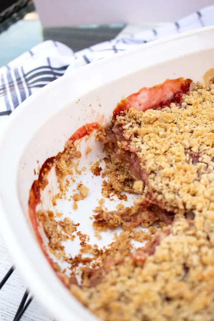 Close-up view of the strawberry rhubarb crisp in a white casserole dish.