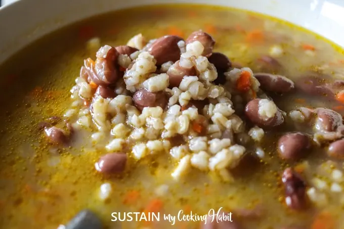 Close up image of romano beans and barley soup.