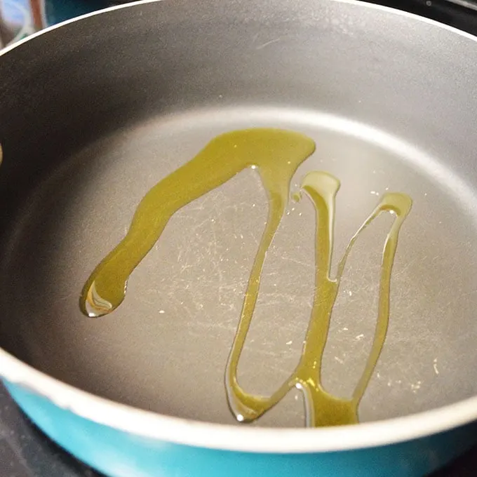 Frying pan with olive oil drizzled inside.