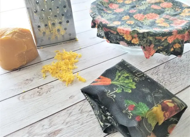 Materials needed to make a sustainable beeswax wrap, including a cheese grater, beeswax and fabric.