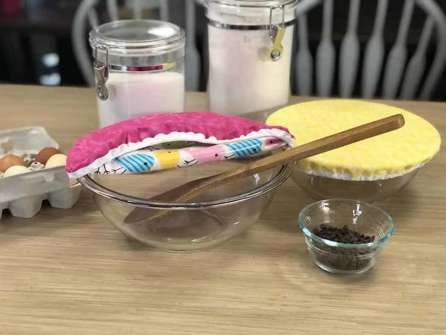 Baking supplies and glass bowls covered with reusable materials.