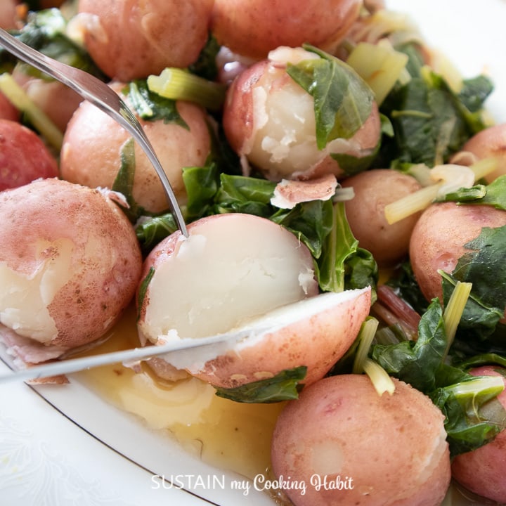 Boiled Swiss chard with baby potatoes on a serving platter.
