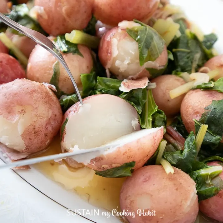 Boiled Swiss chard with baby potatoes on a serving platter.