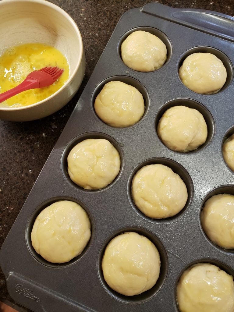 dough divided and placed inside greased muffin tray for baking