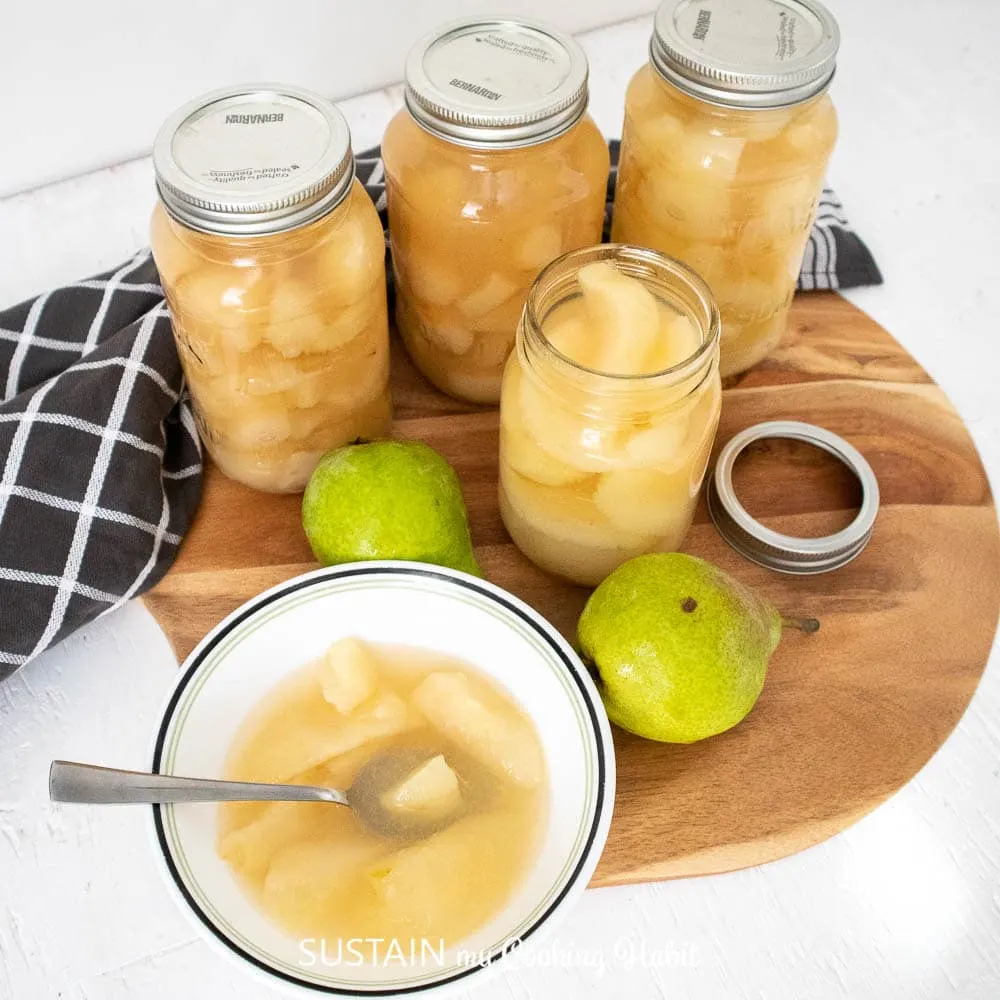 Fresh pairs, canned pear compote and compote in a bowl placed on a serving tray.