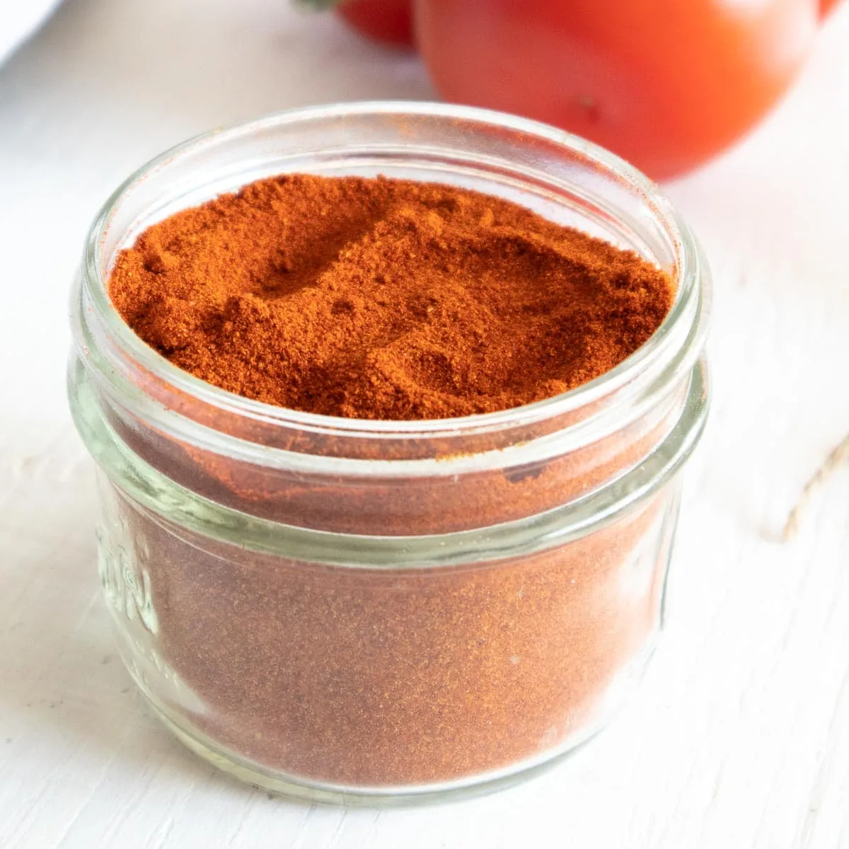 Dried tomato powder in a glass jar.