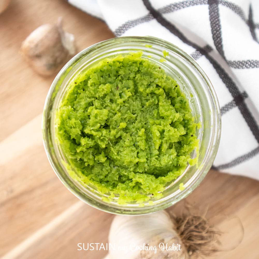 Overheard view of garlic scapes pesto in a jar.