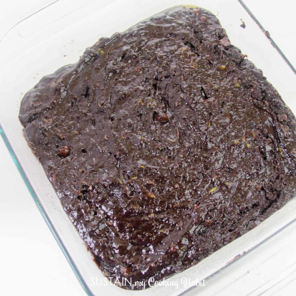 Placing the double chocolate zucchini mixture into a baking dish.