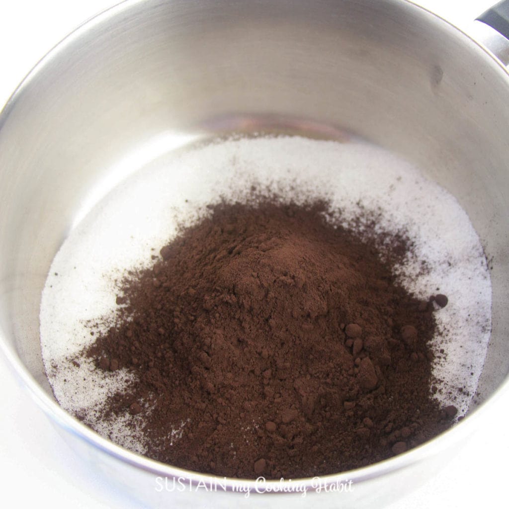 Combinging sugar and cocoa powder in a saucepan.