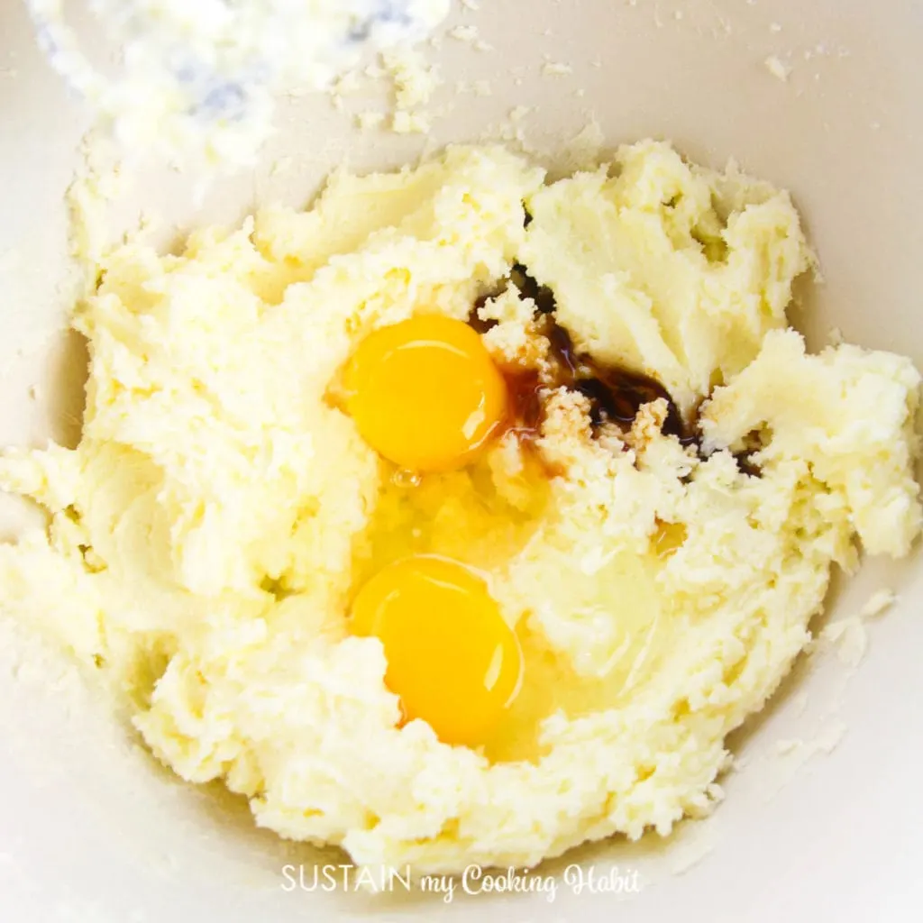 Adding eggs and vanilla extract into a mixture of butter and sugar.