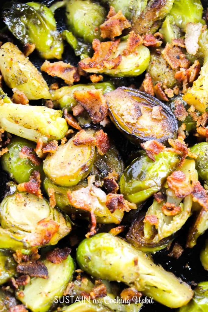 Adding chopped bacon to the cooked brussel sprouts.