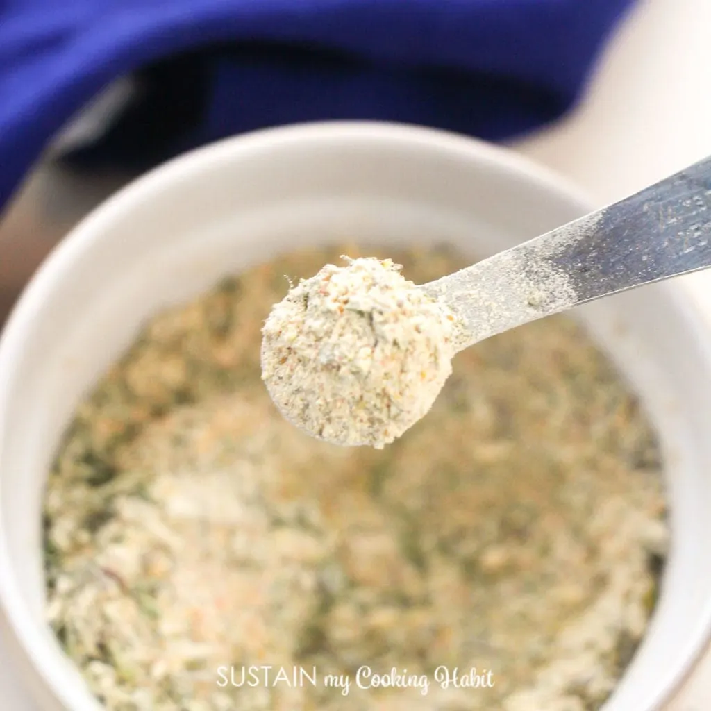 Close up of garlic and herb seasoning mix on a spoon.
