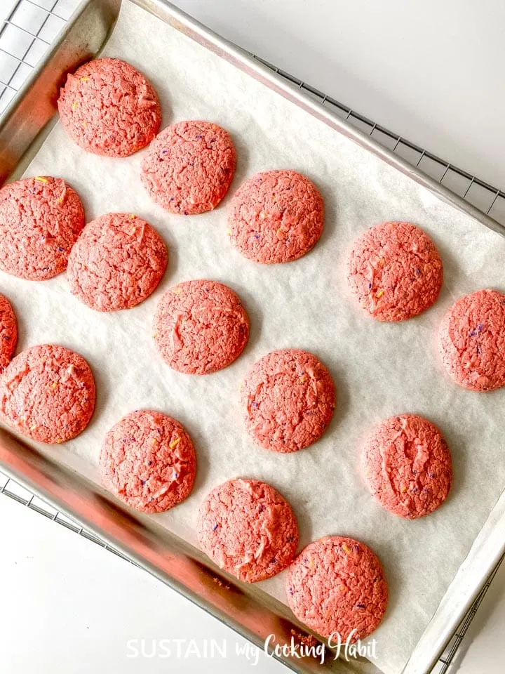 Baked strawberry cake mix cookies on a cookie sheet.