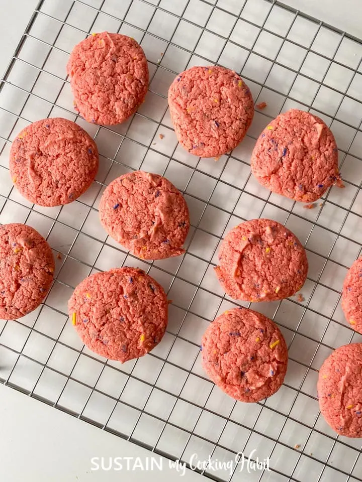 Baked strawberry cake mix cookies placed on a cooling rack.