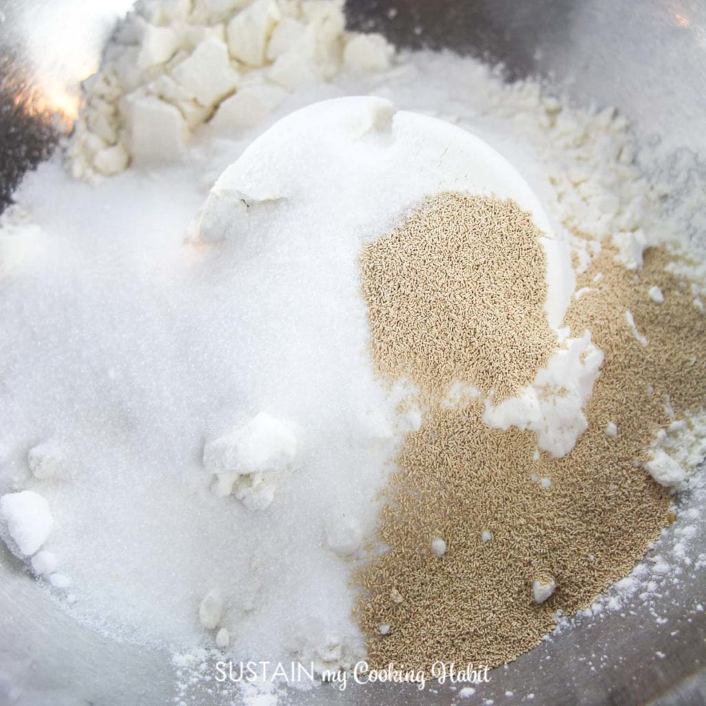Combining flour, sugar, salt and yeast into a bowl. 
