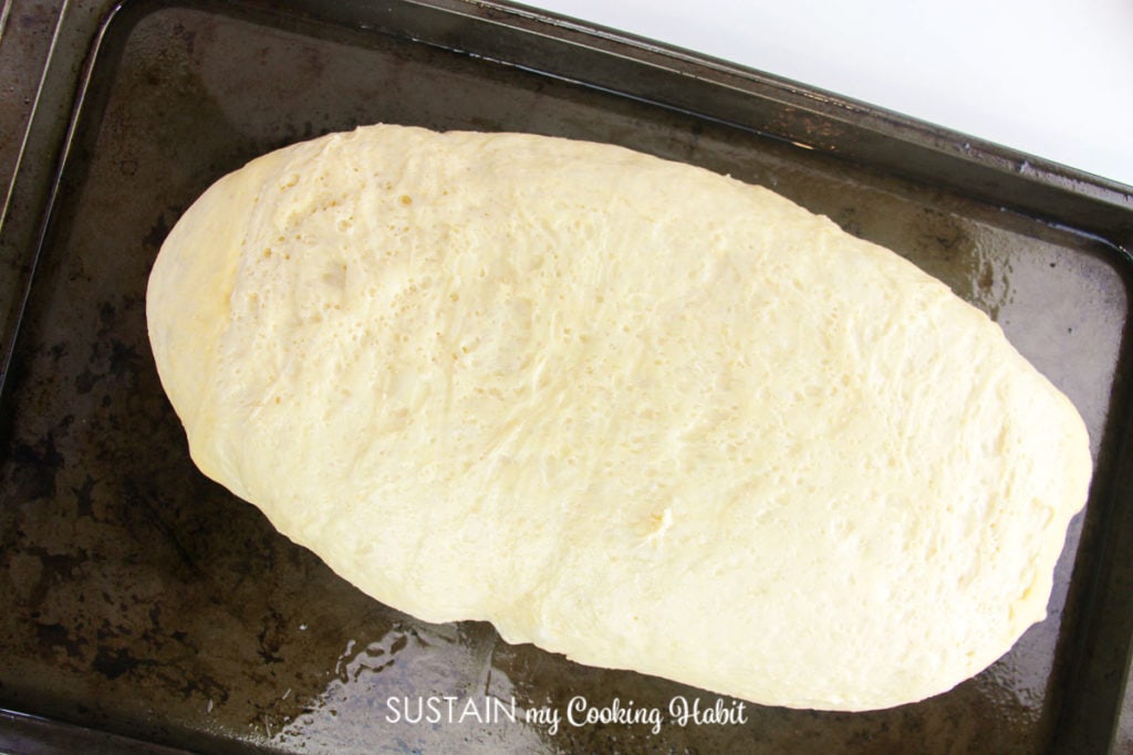 Forming the dough into a log shape and putting it on a baking sheet.