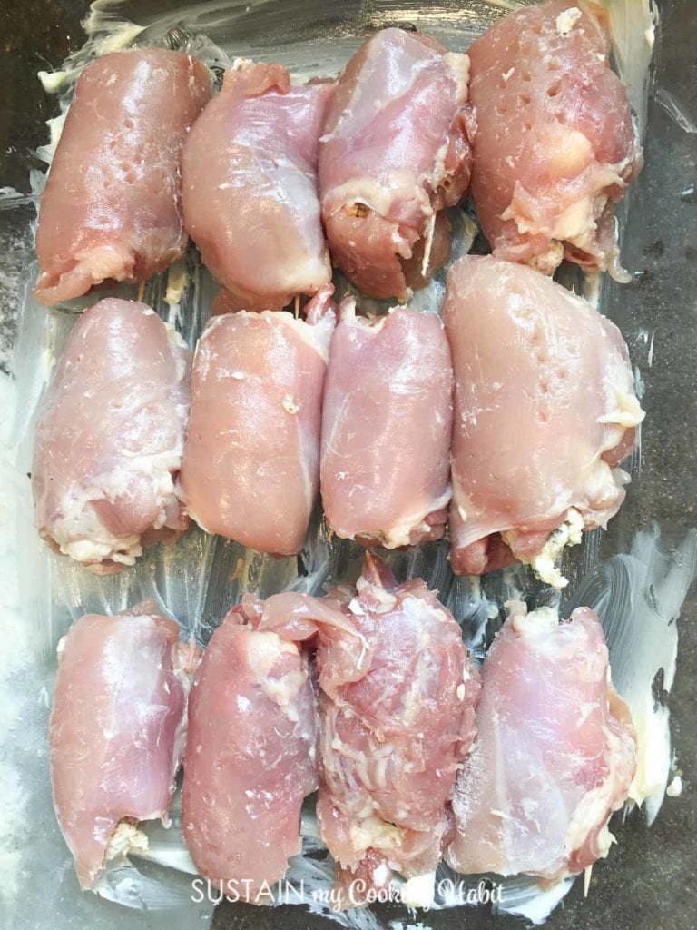 Uncooked chicken thighs in a pan.