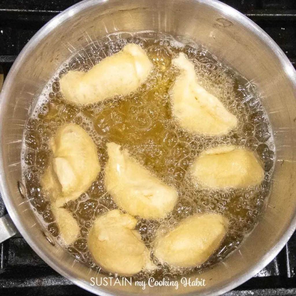 Frying the dough in a pot of oil.