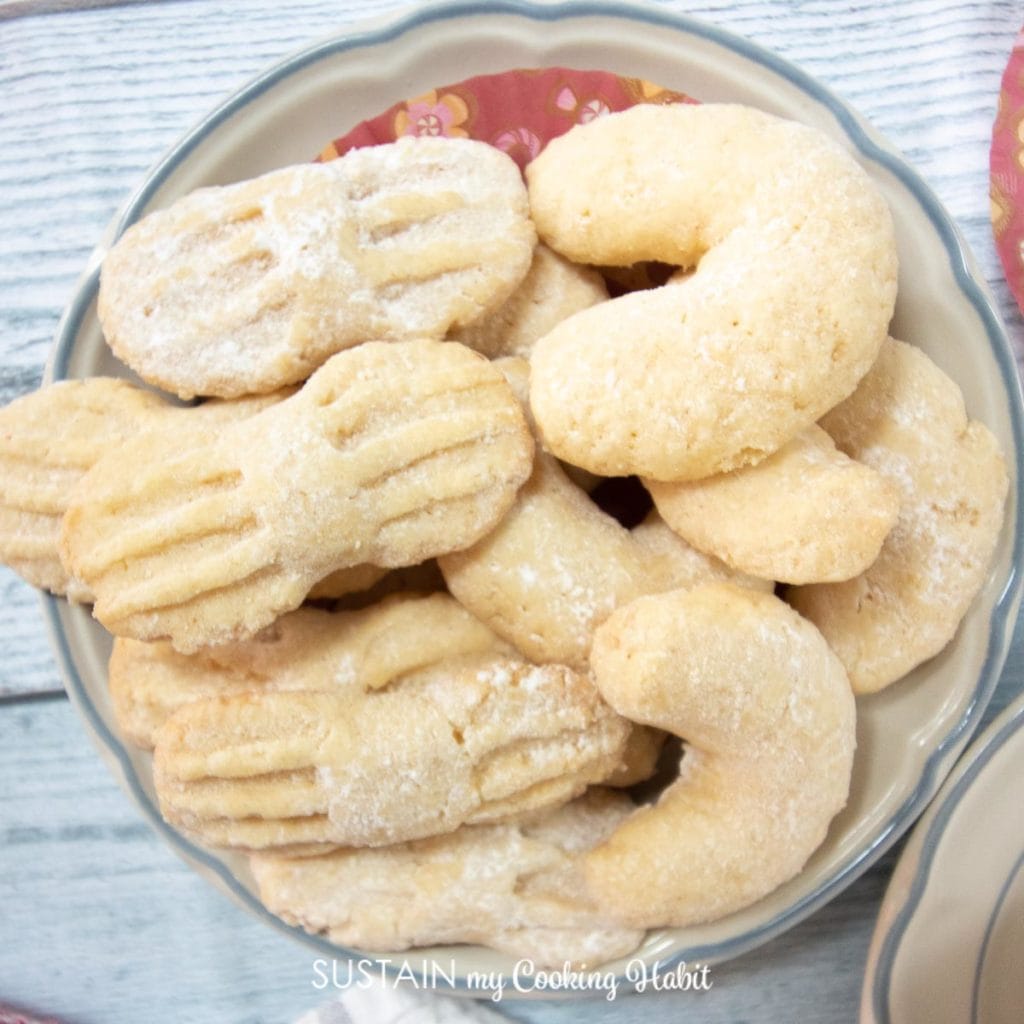 small plate of coconut crescent moon cookies and bow shaped cookies