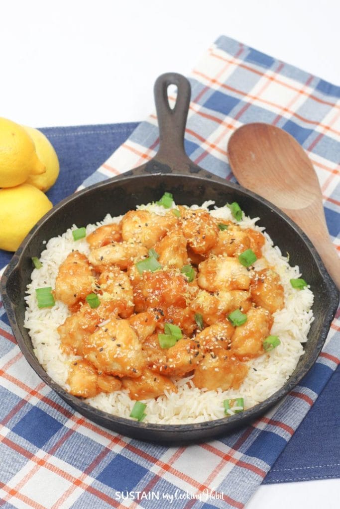 Lemon chicken and rice in a black pan.