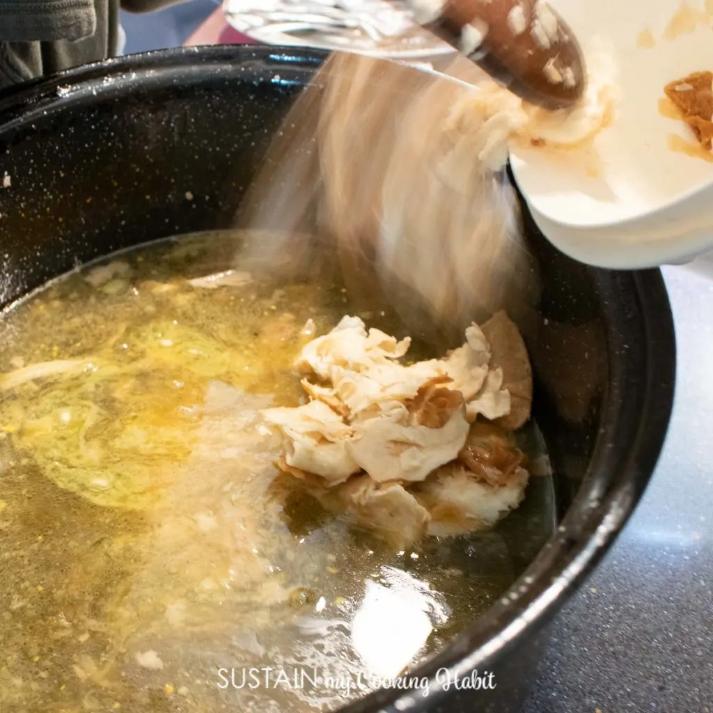 Adding mlince noodles to pan of grease.