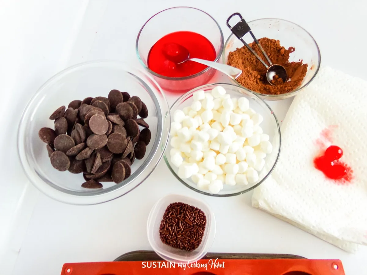 Ingredients need to for a Chocolate covered cherry hot cocoa bomb recipe including chocolate melts, hot cocoa, marshmallows and cherries.