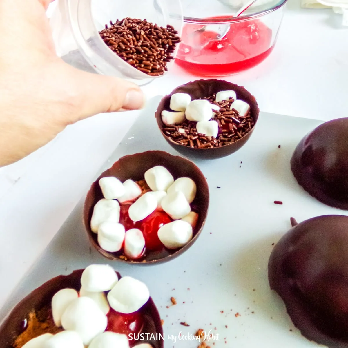 Filling the chocolate cup with ingredients.