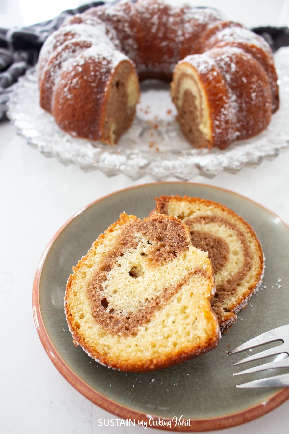 Marbled bundt cake with a slice taken out and placed on a plate.