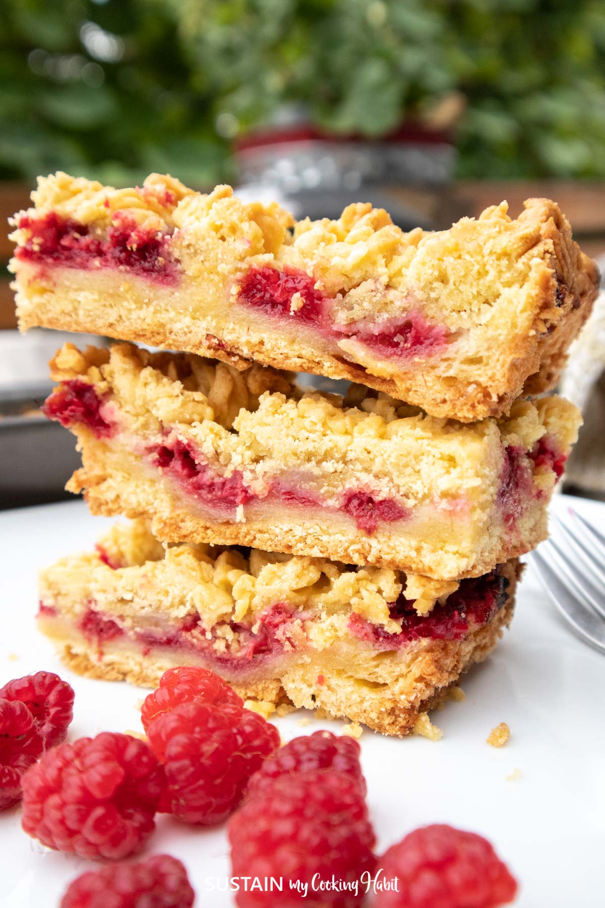 Raspberry dessert squares stacked on top of each other.