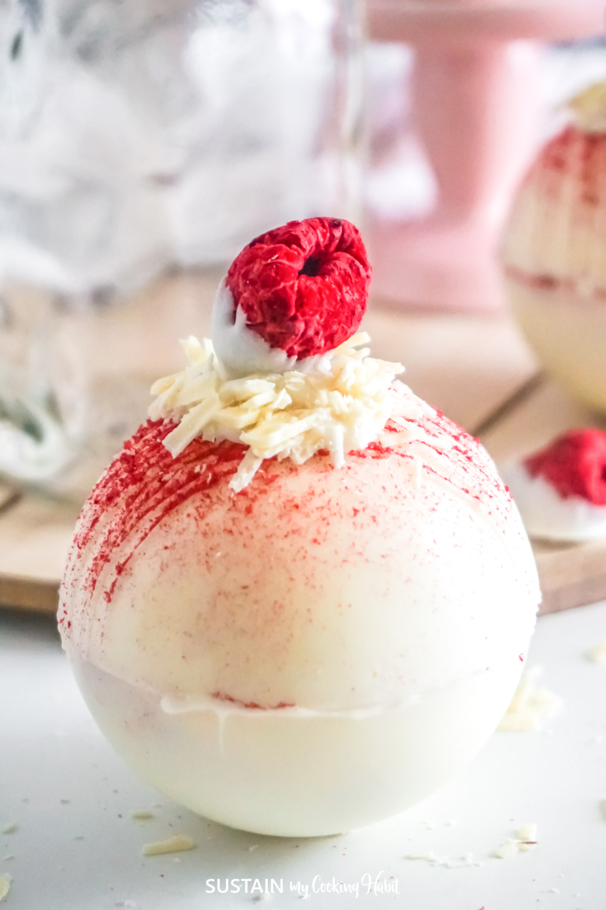 Close up of a white chocolate raspberry hot cocoa bomb.