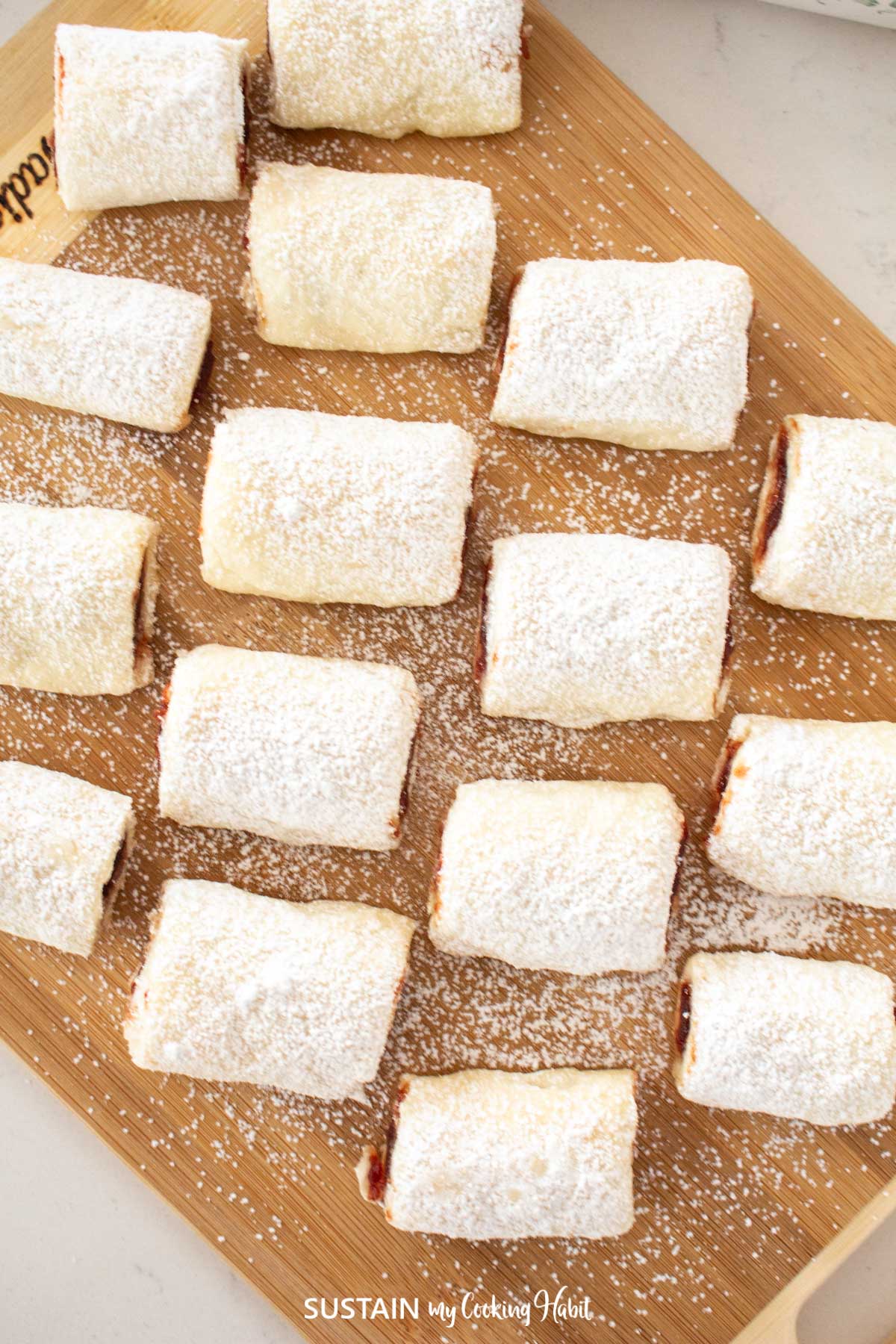 Overhead view of jam filled cookie rolls sprinkled with powdered sugar.