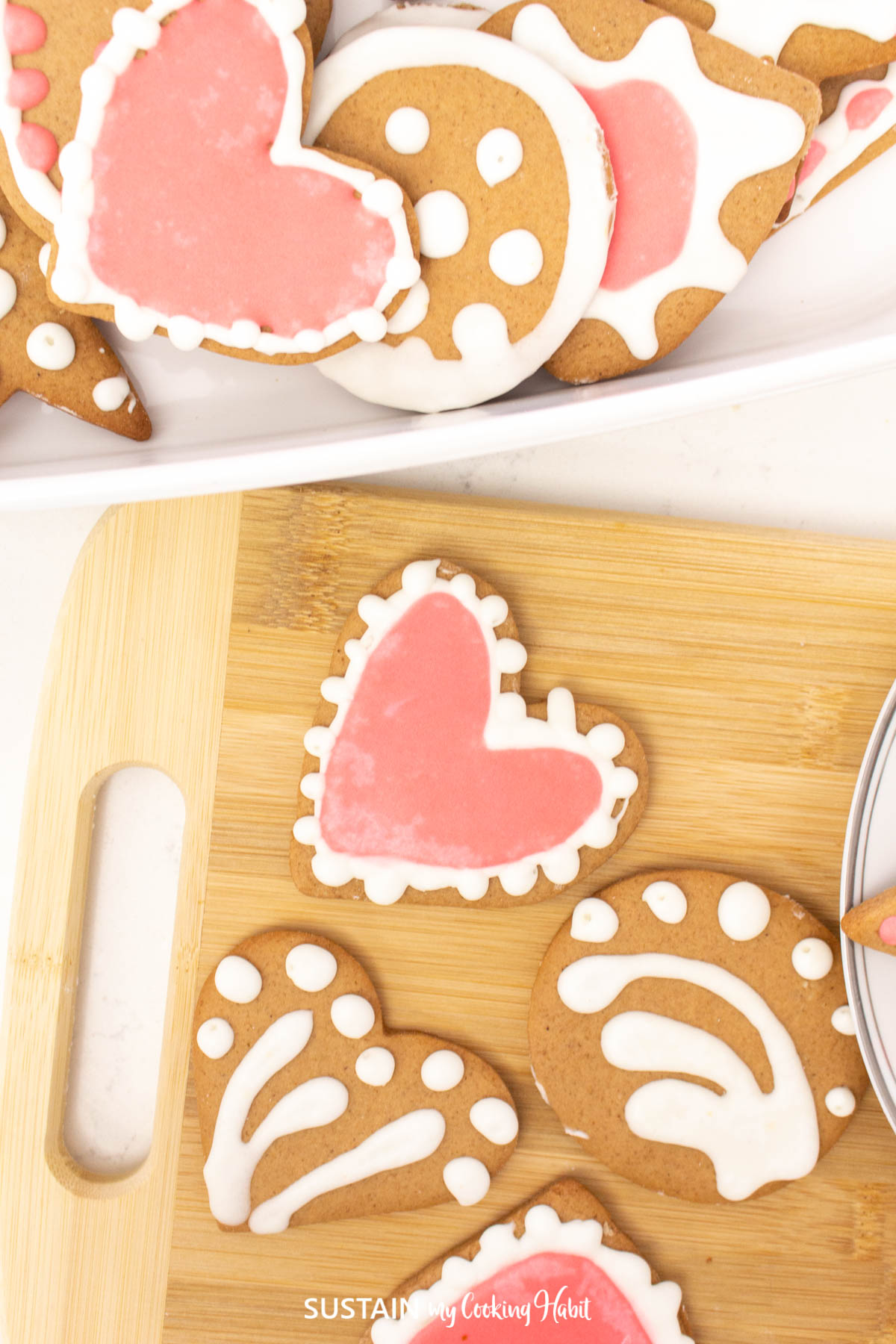 Honey sugar cookiescut into shapes like stars and hearts placed onto a cutting board.