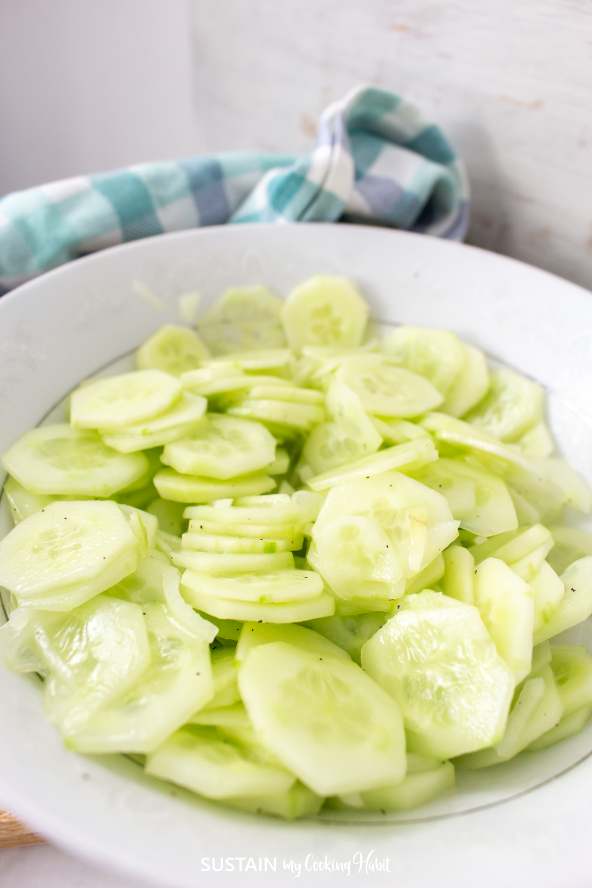 Close up of non-creamy sliced cucumber salad in a bowl.