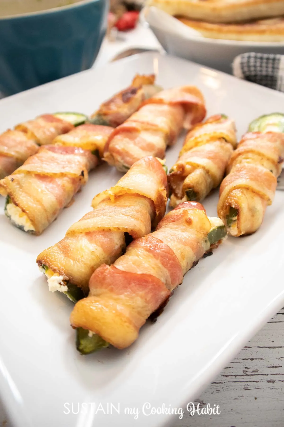 Bacon wrapped jalapeno poppers on a plate.