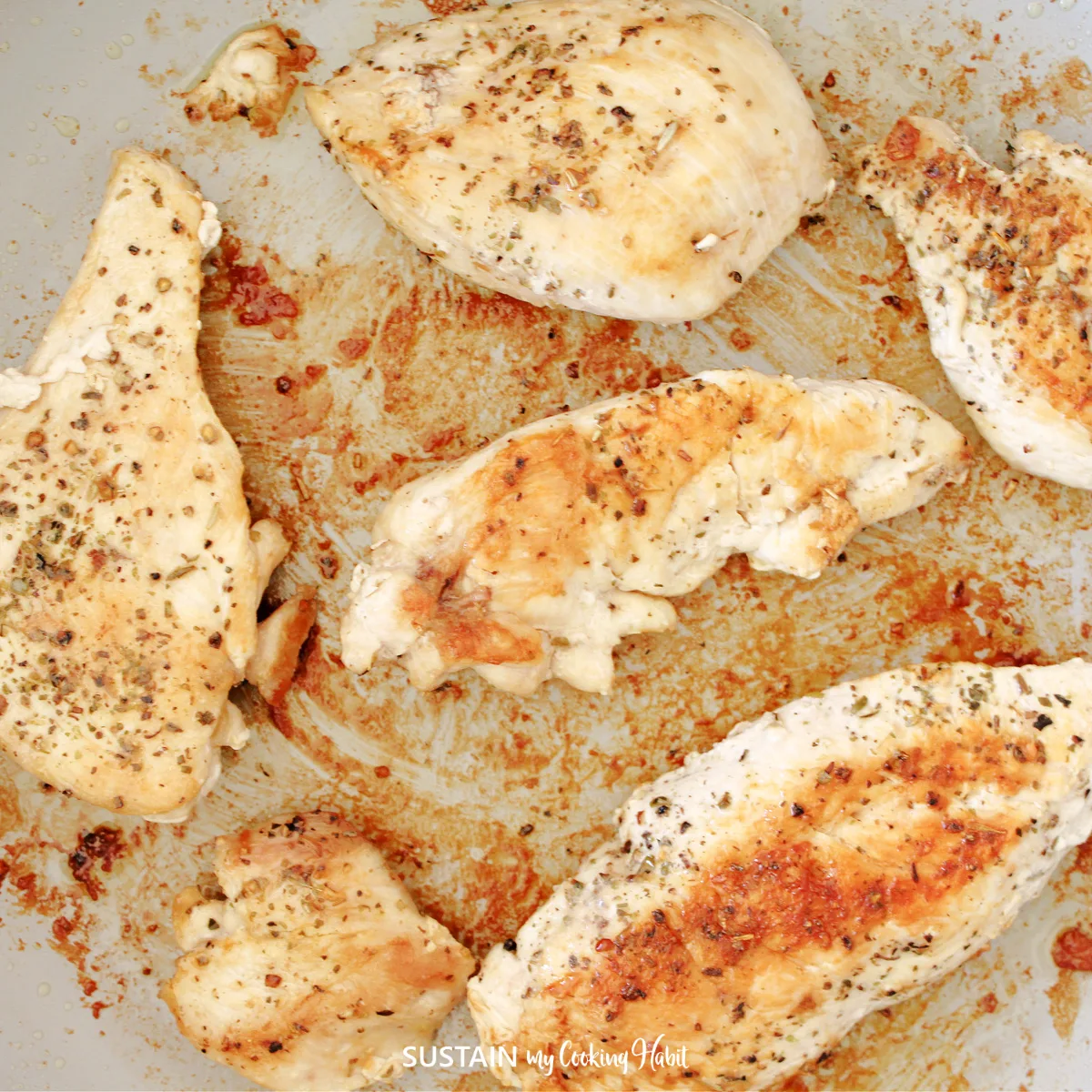 Cooked chicken breast in a pan.