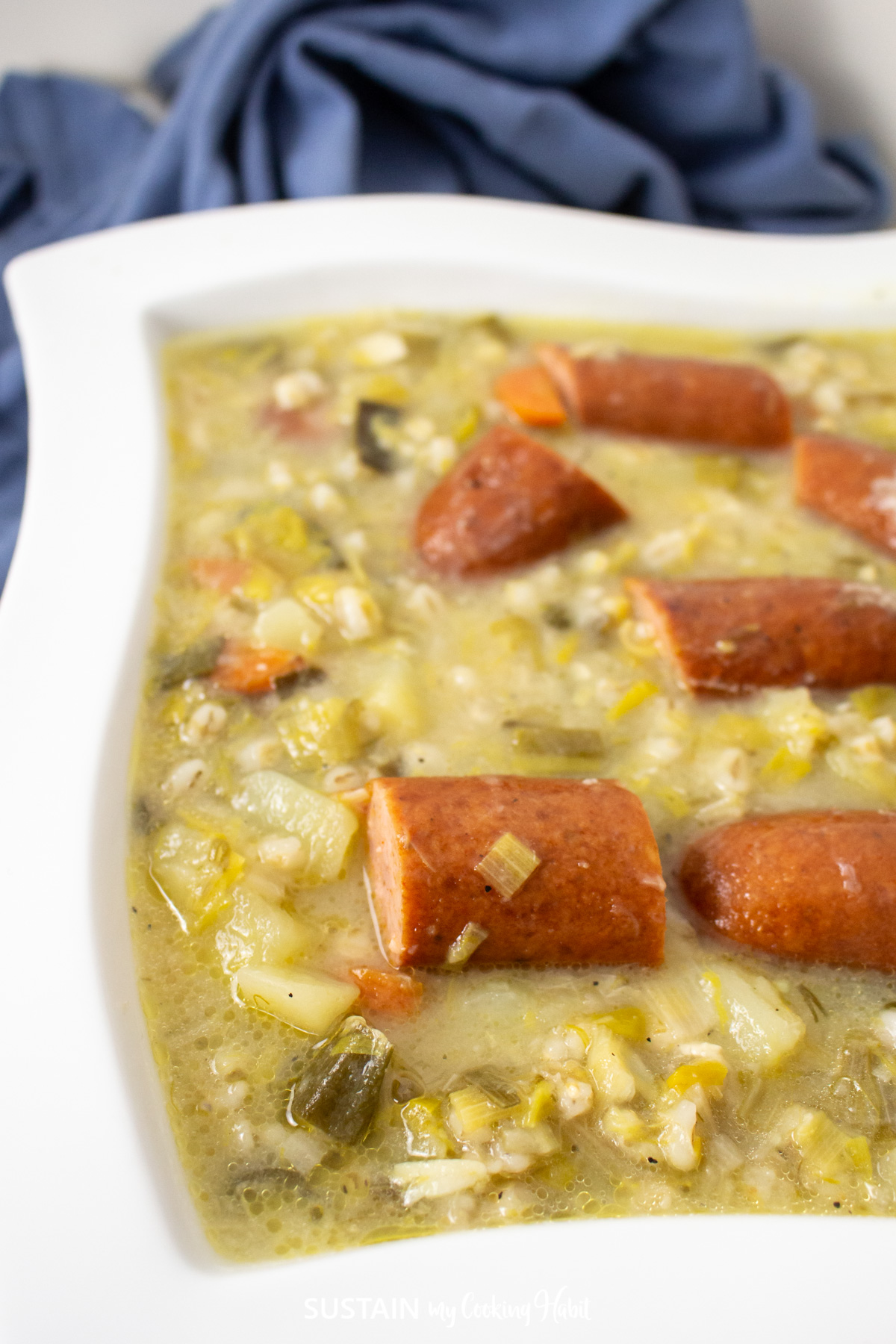Close up of Leek and sausage soup in a bowl.