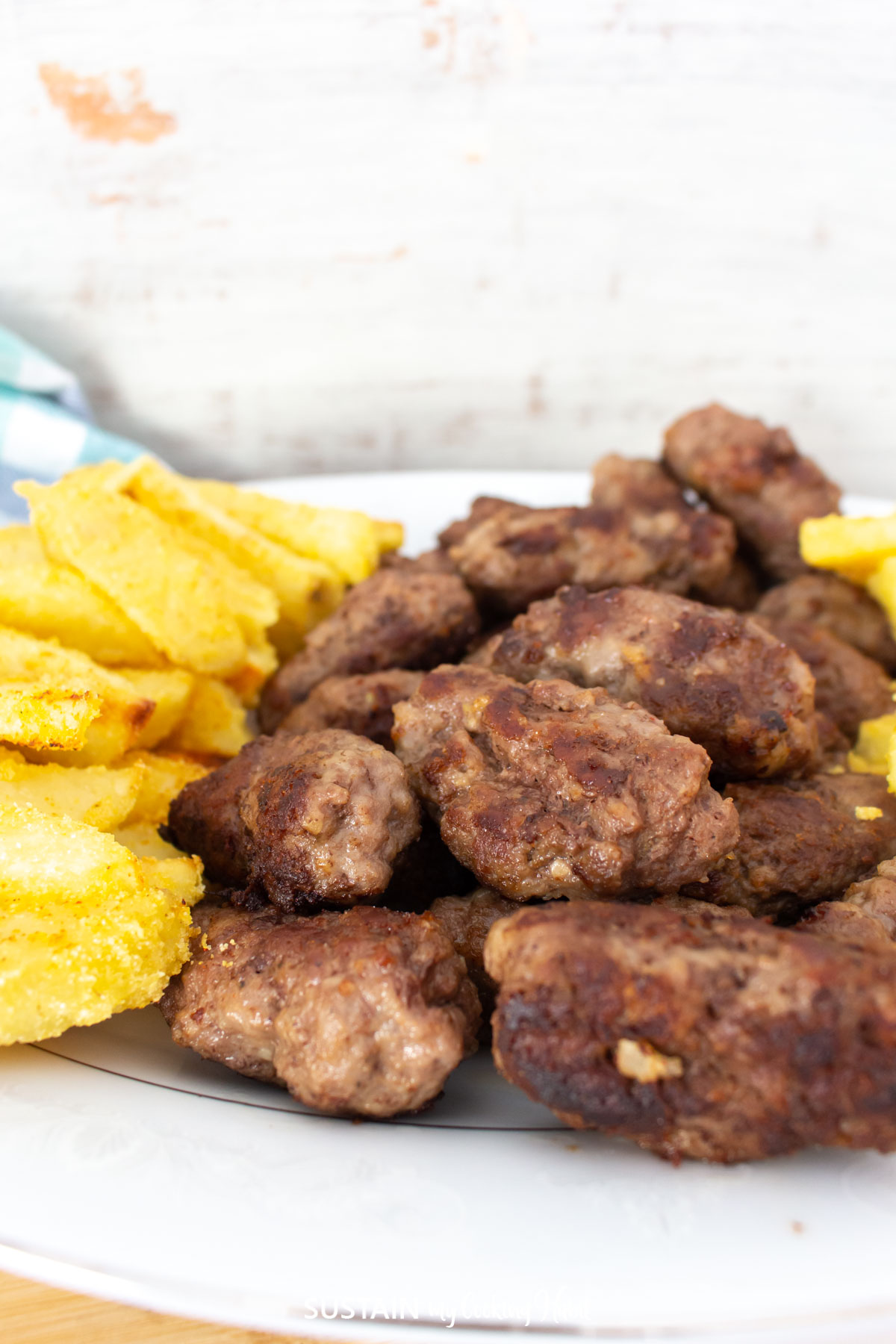 Croatian cevapi mini sausages stacked on a plate.