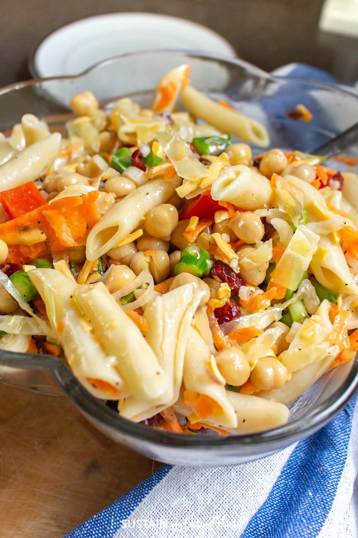 Close up of chickpea pasta salad in a glass bowl.
