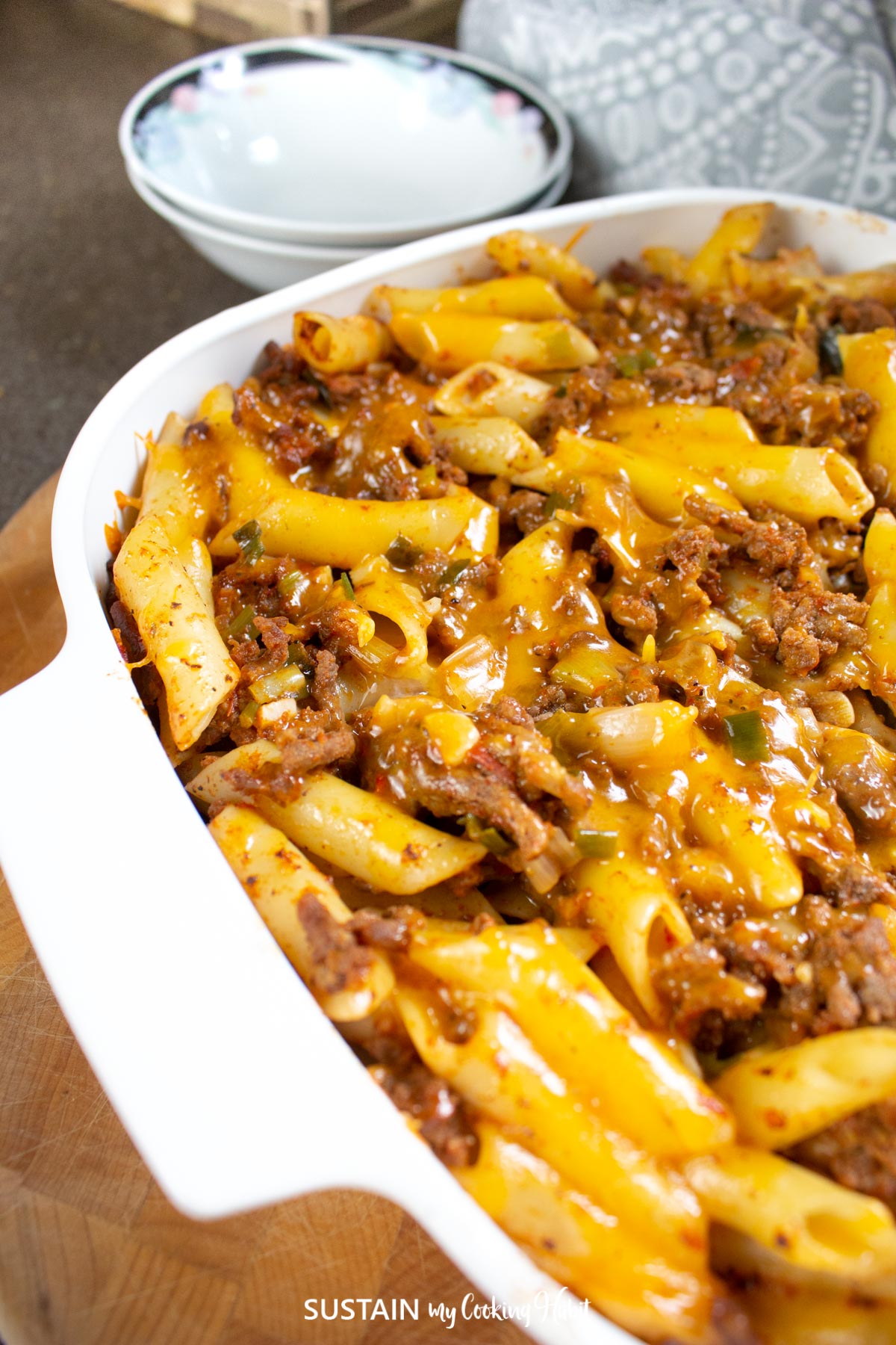 Baked penne pasta with ground beef in a serving dish.