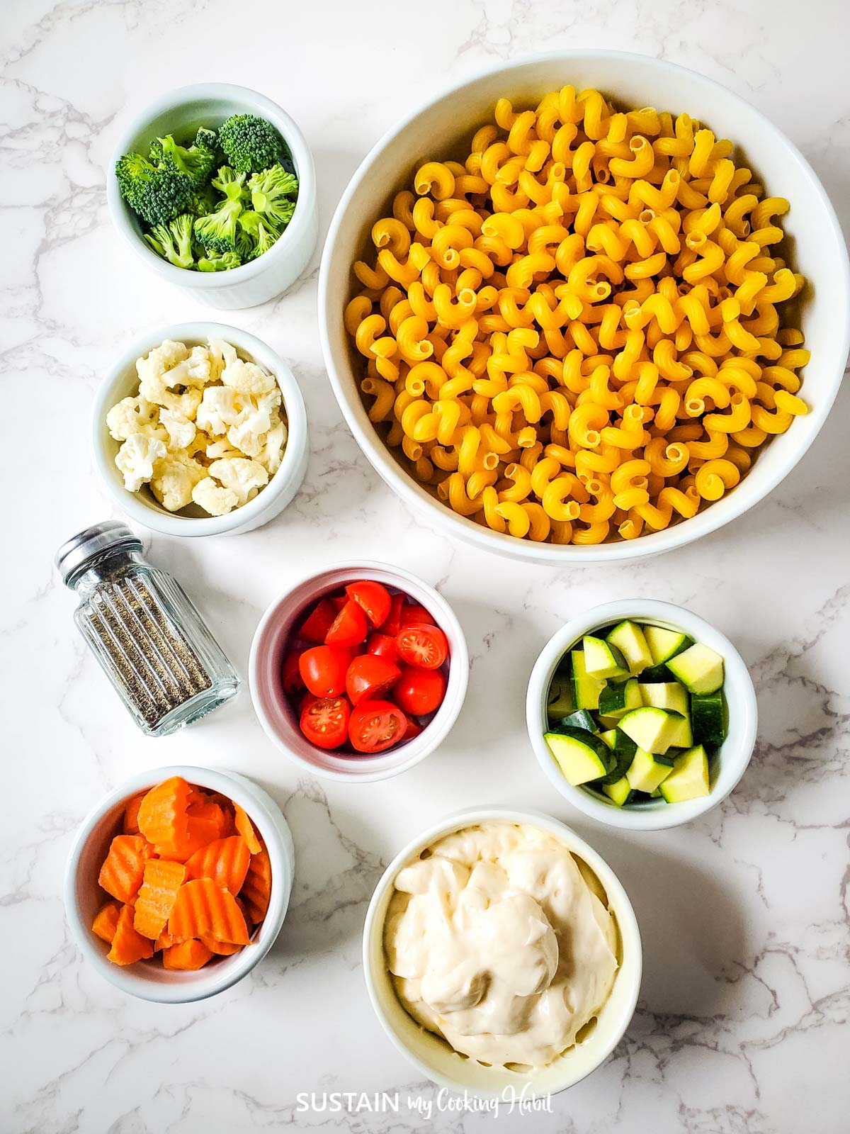 Ingredients needed to make pasta salad including pasta, vegetables, pepper and miracle whip.