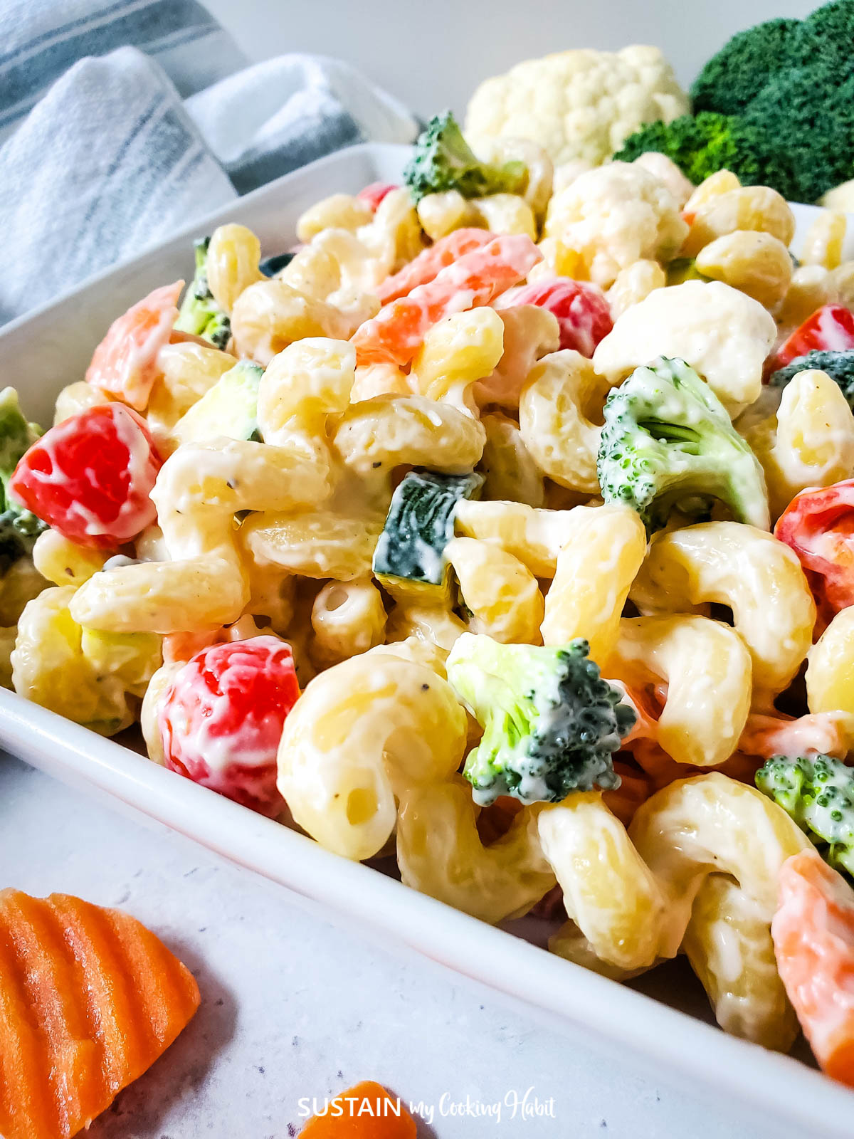Close up of creamy pasta salad loaded with veggies.