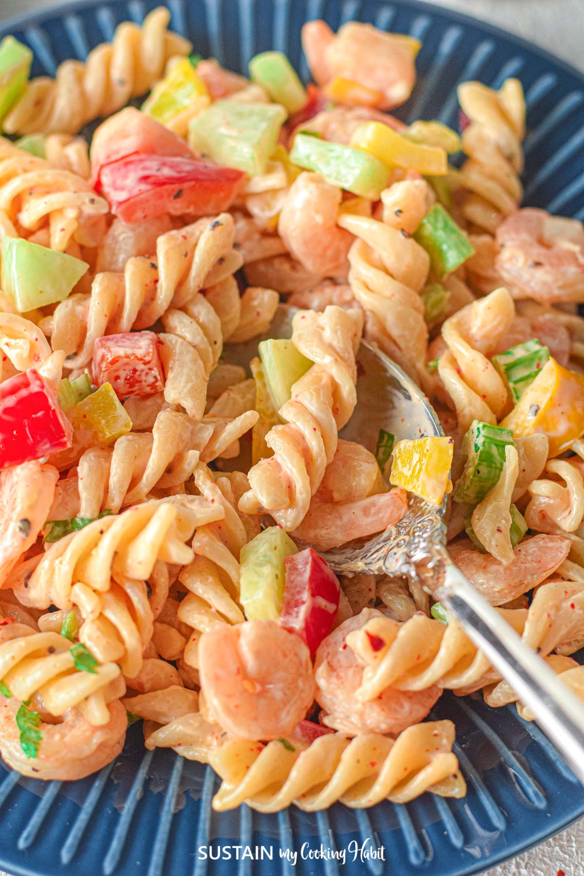 Close up of pasta salad with a fork in it