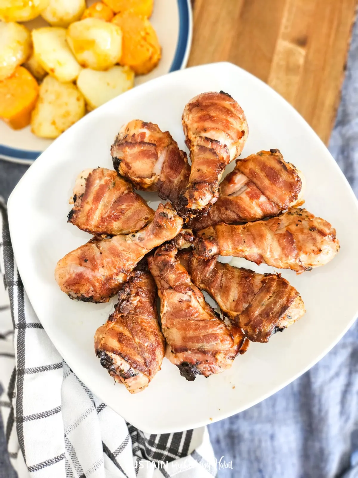 Overhead view of bacon wrapped drumsticks on a plate.