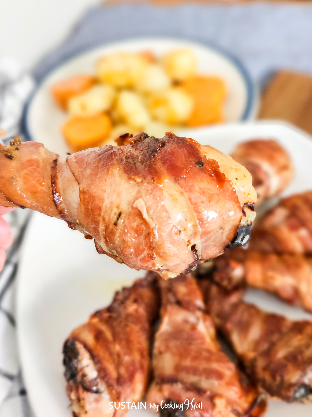 Close up of a bacon wrapped drumstick.