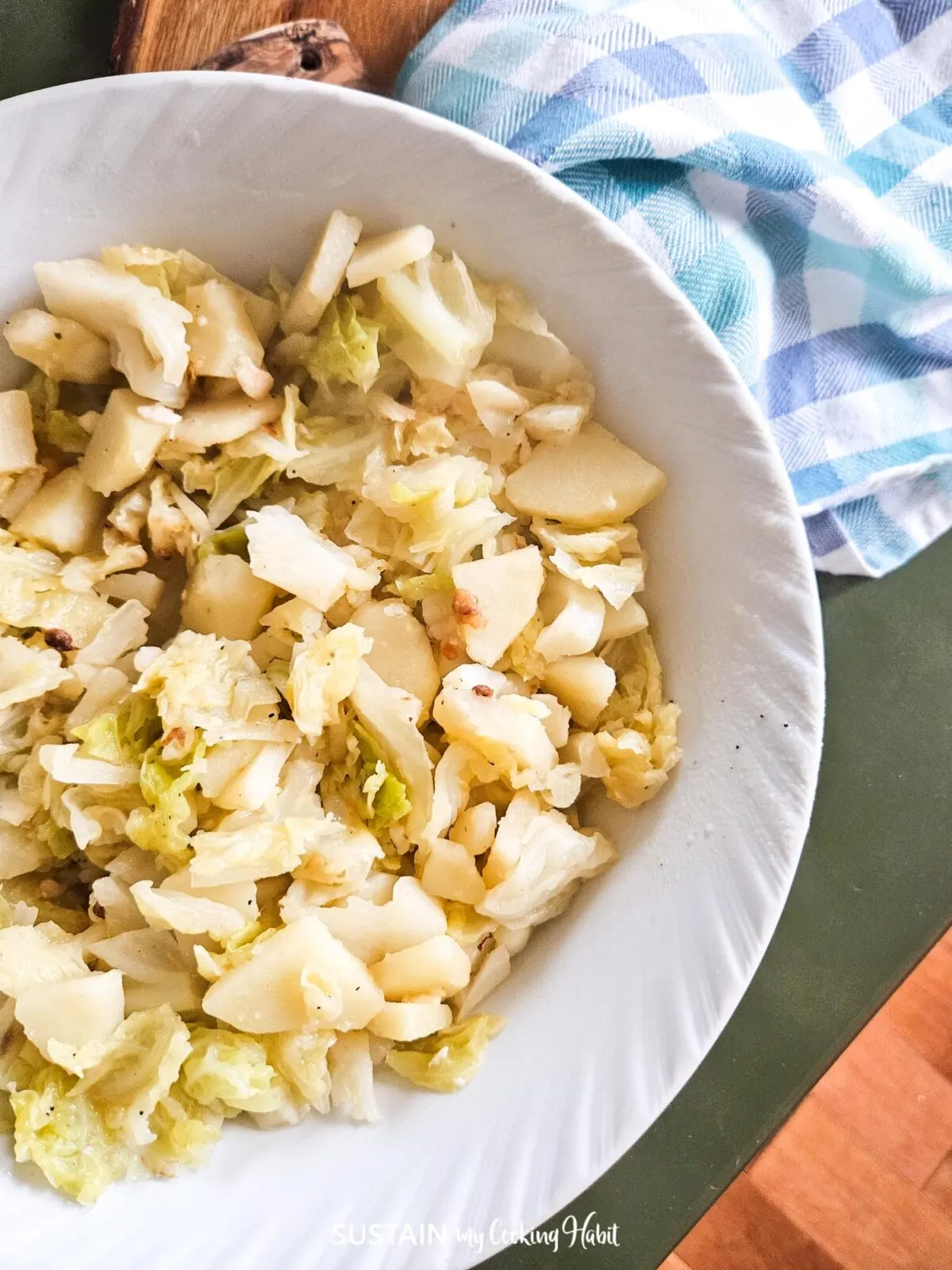 Cooked savoy cabbage and potato side dish in a bowl.