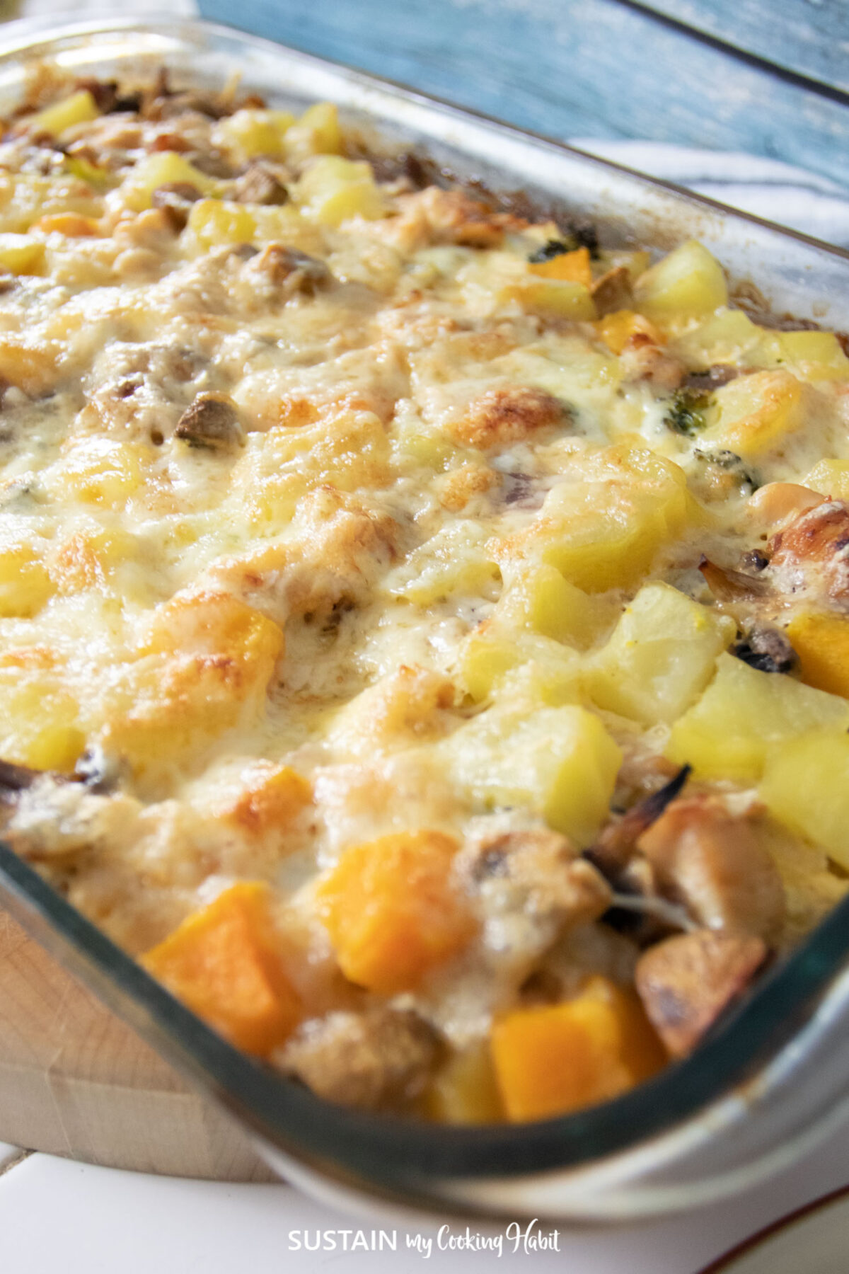 Close up of chicken and potato casserole covered with melted cheese.