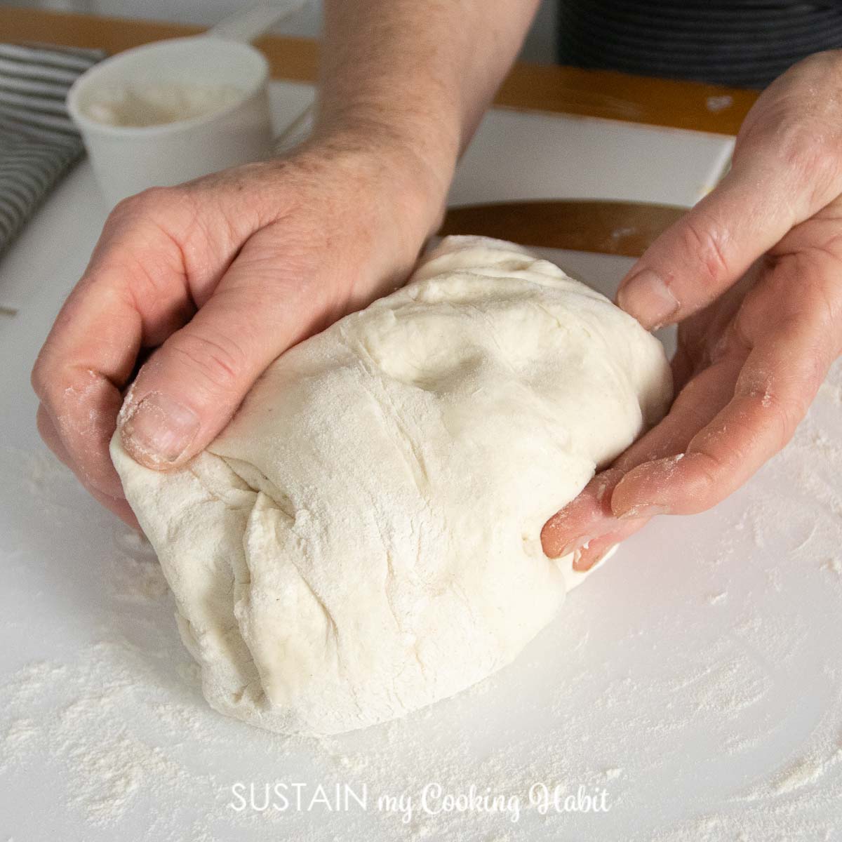 Hands kneading pizza dough.