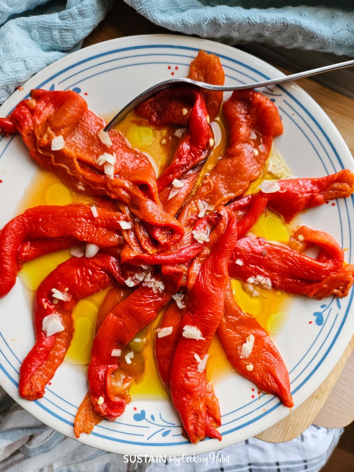 Roasted antipasto peppers on a plate with garlic and oil.